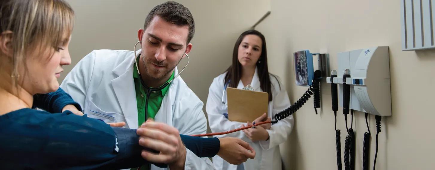 A MPAS student conducting a patient assessment as part of his degree program.